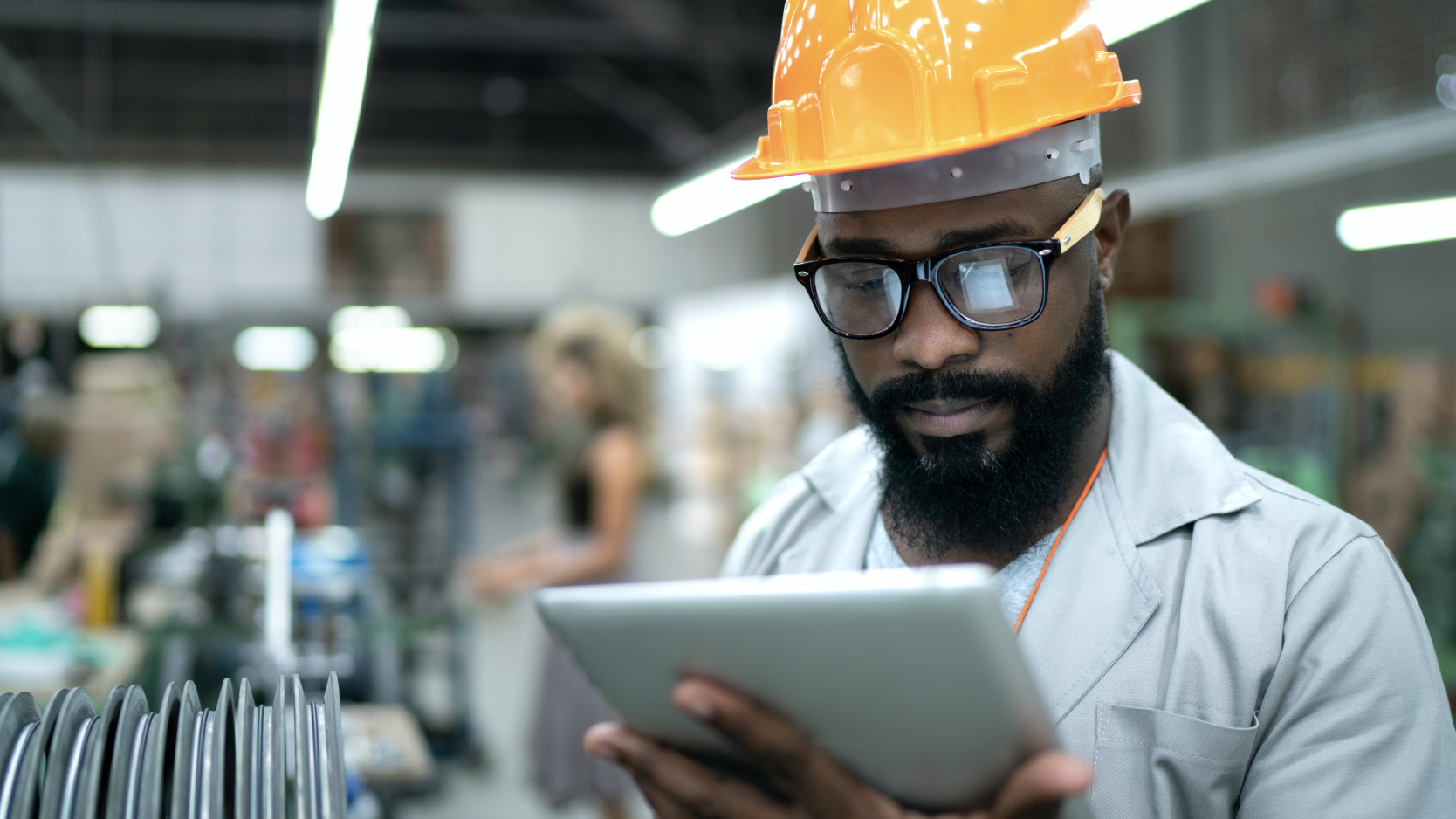 Black male engineer in helmet with tablet