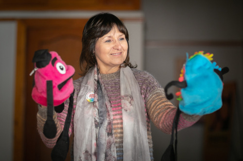 Photo of Petro holding two puppets, one in each hand.
