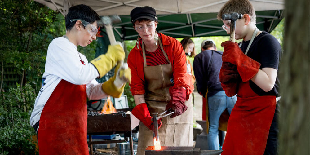 A group of young people working on metal.