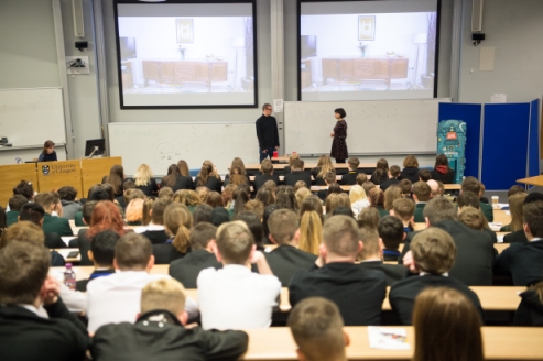 Large audience of school students in a lecture theatre