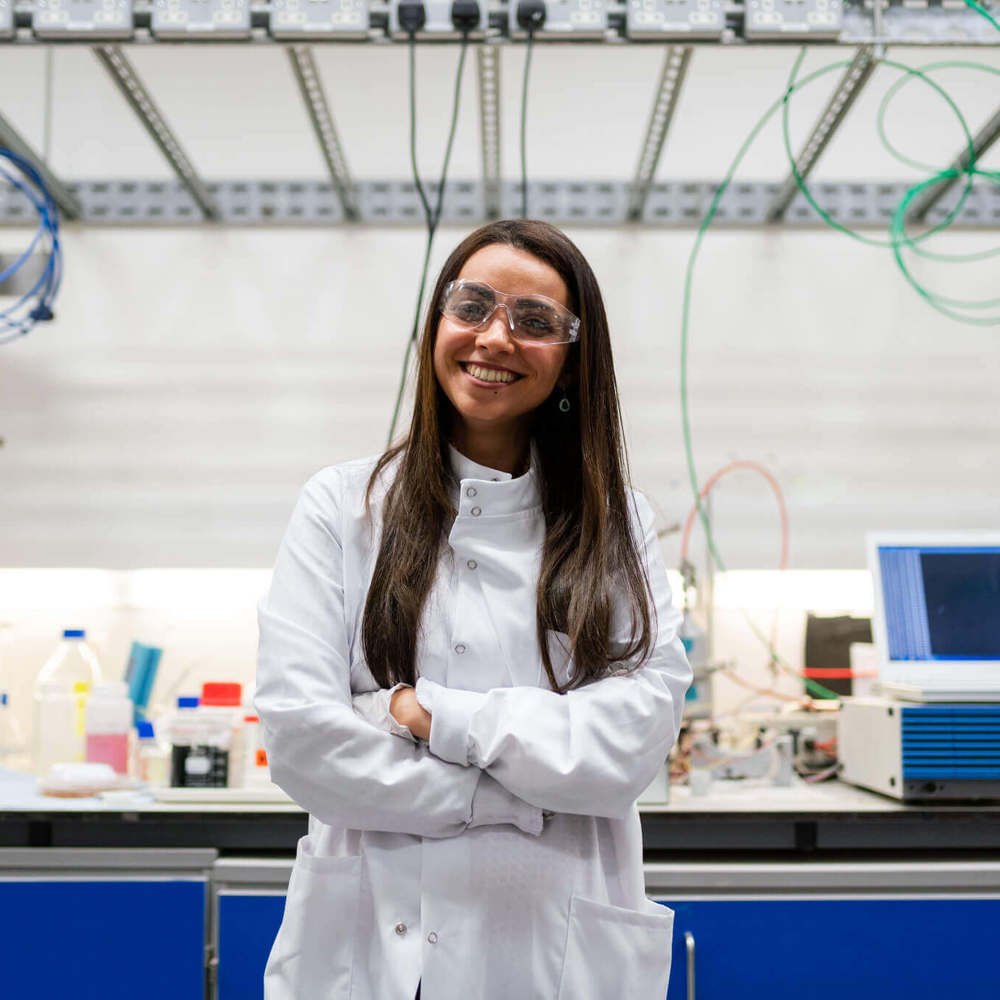 Female chemical engineer in laboratory develops clean energy storage solutions.