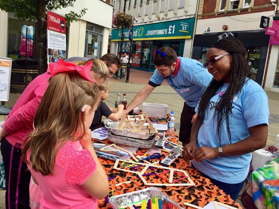 SMASHfest team running fun activity making structures using lolly sticks with families