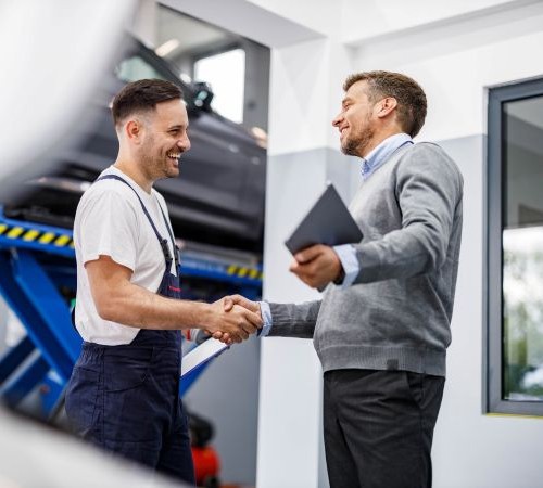 Two Men Shake Hands In An Engineering Environment
