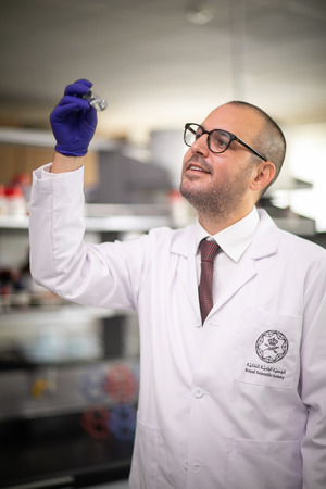 Photo of Kyle staring at a test tube in a lab.