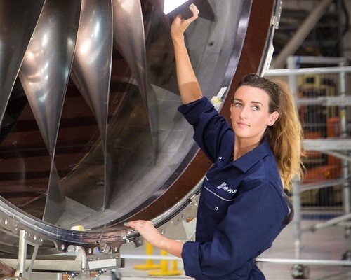 Person shining a light into a large turbine.