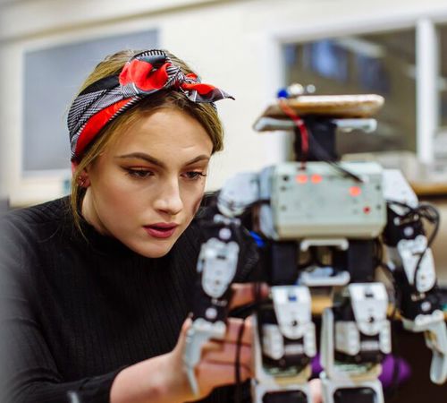 Female Electrical Engineer Working Robot