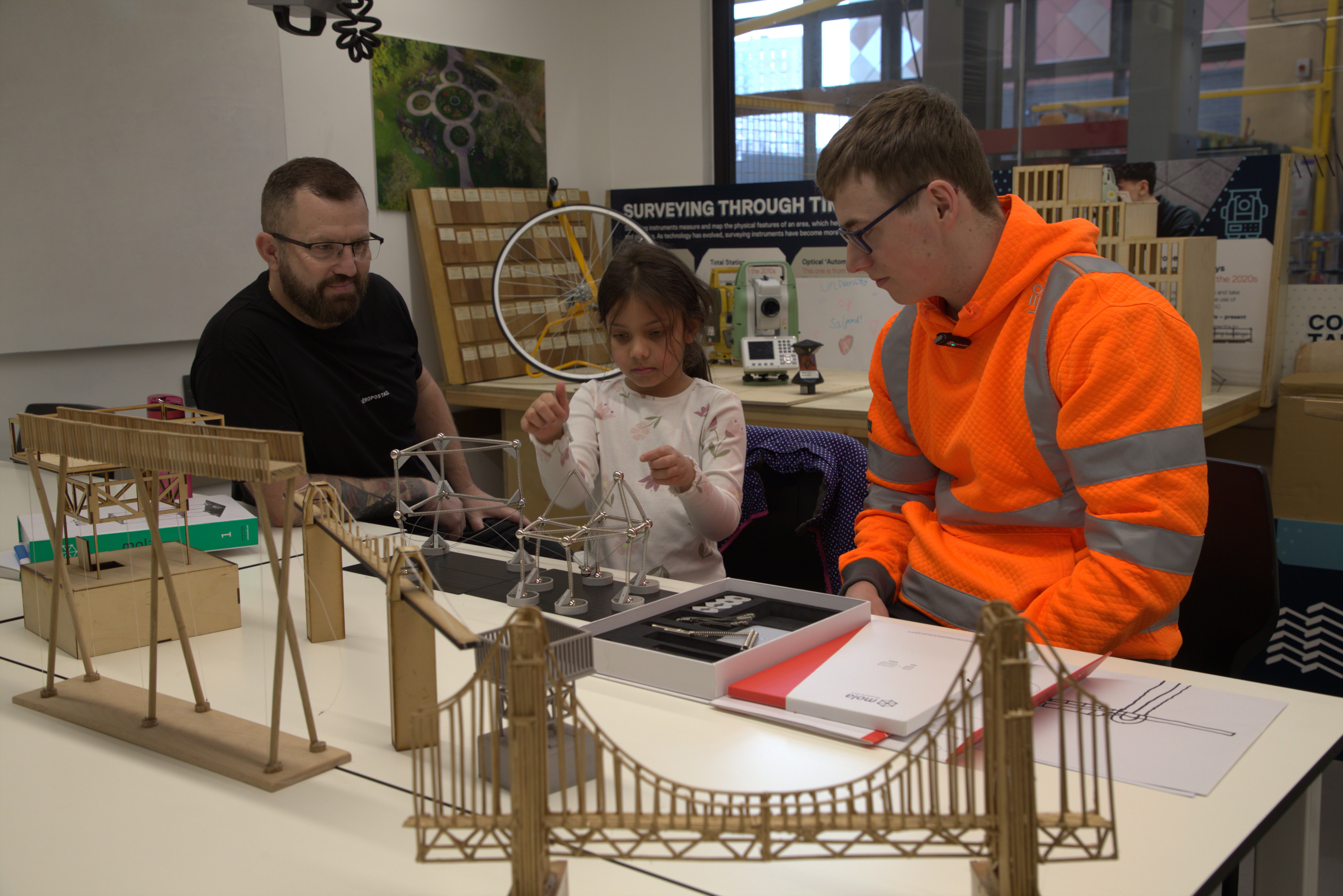 A civil engineering student and a technician from the University of Salford are explaining civil engineering structures to a primary school student