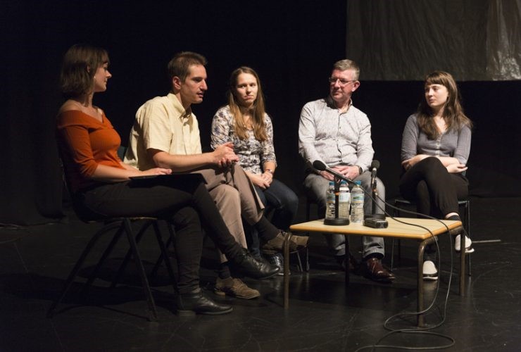 A discussion panel of 5 adults on stage