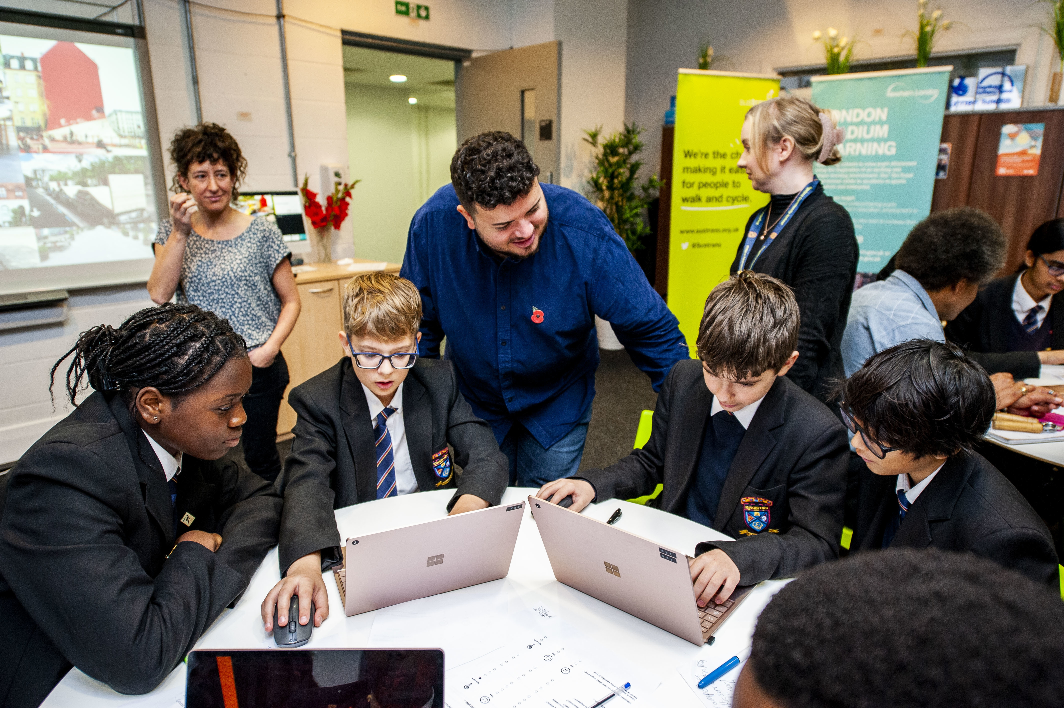 Students around a table working on laptops