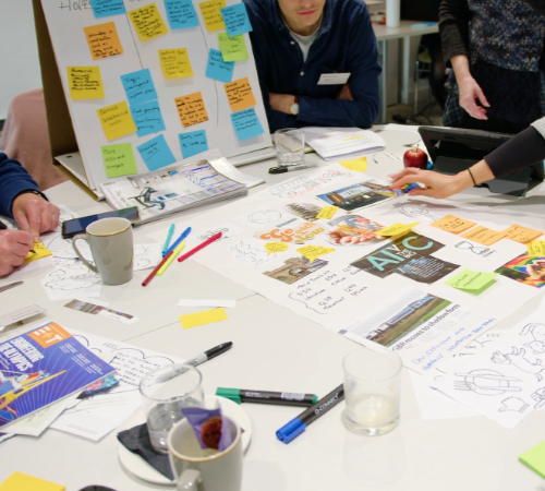 People working on a plan using sticky notes and paper.