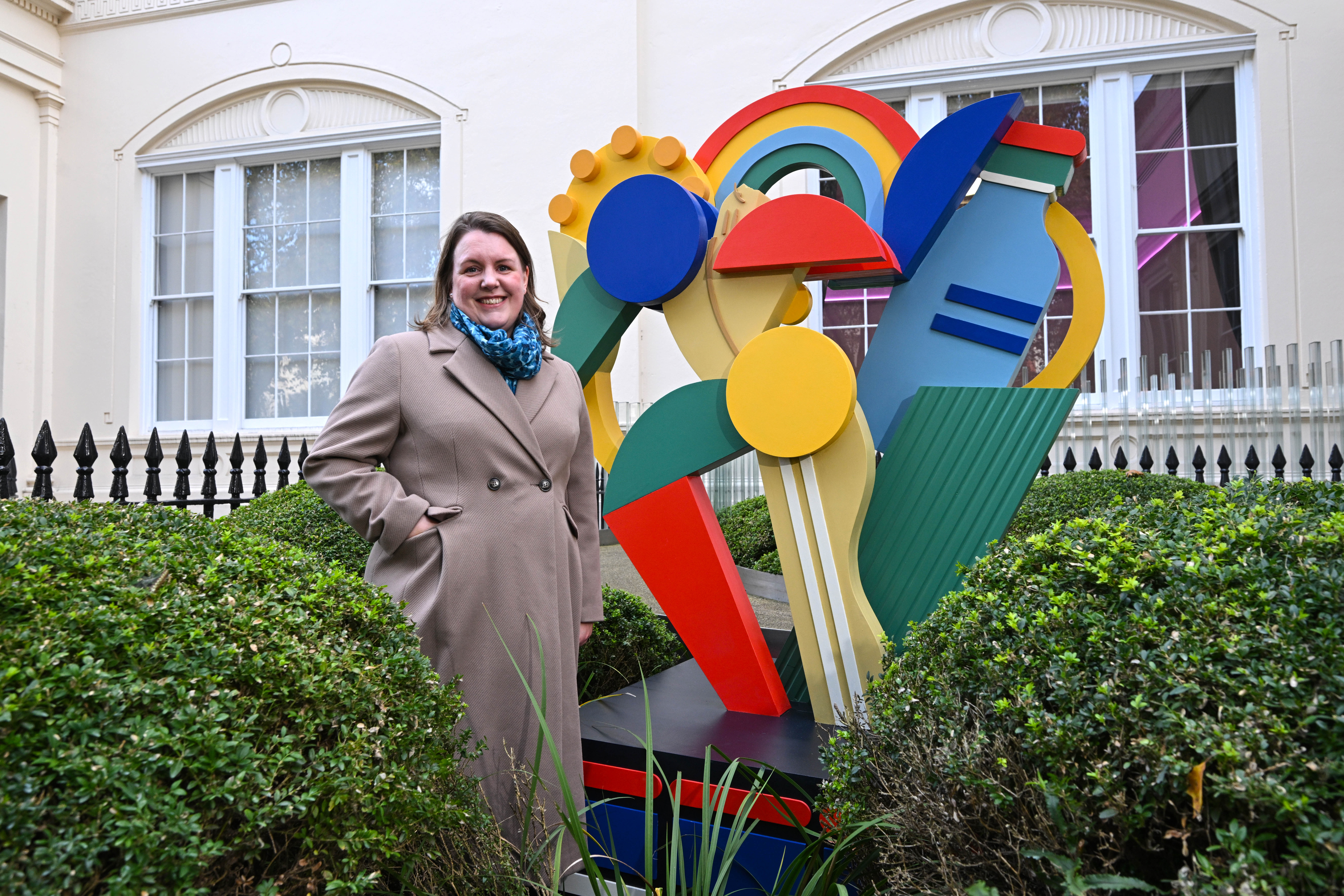 Woman engineer standing by colourful abstract statue