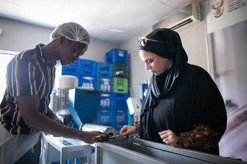 Photo of Maryam with an employee looking down at the manufacturing process.