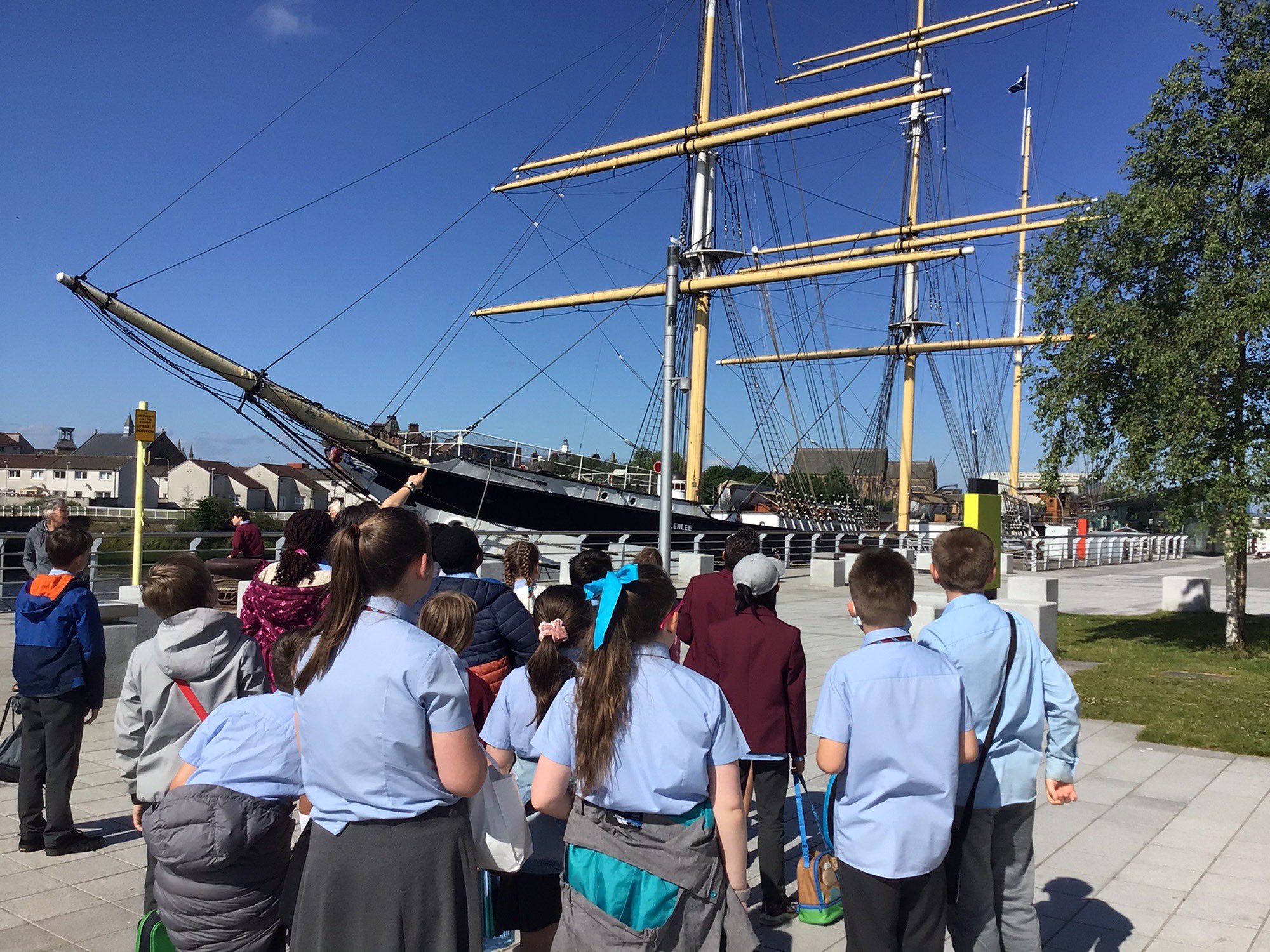 A group of students in front of a tall ship