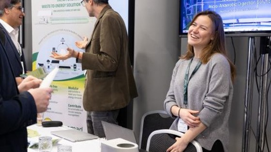 Conference attendees talking at an exhibition stand